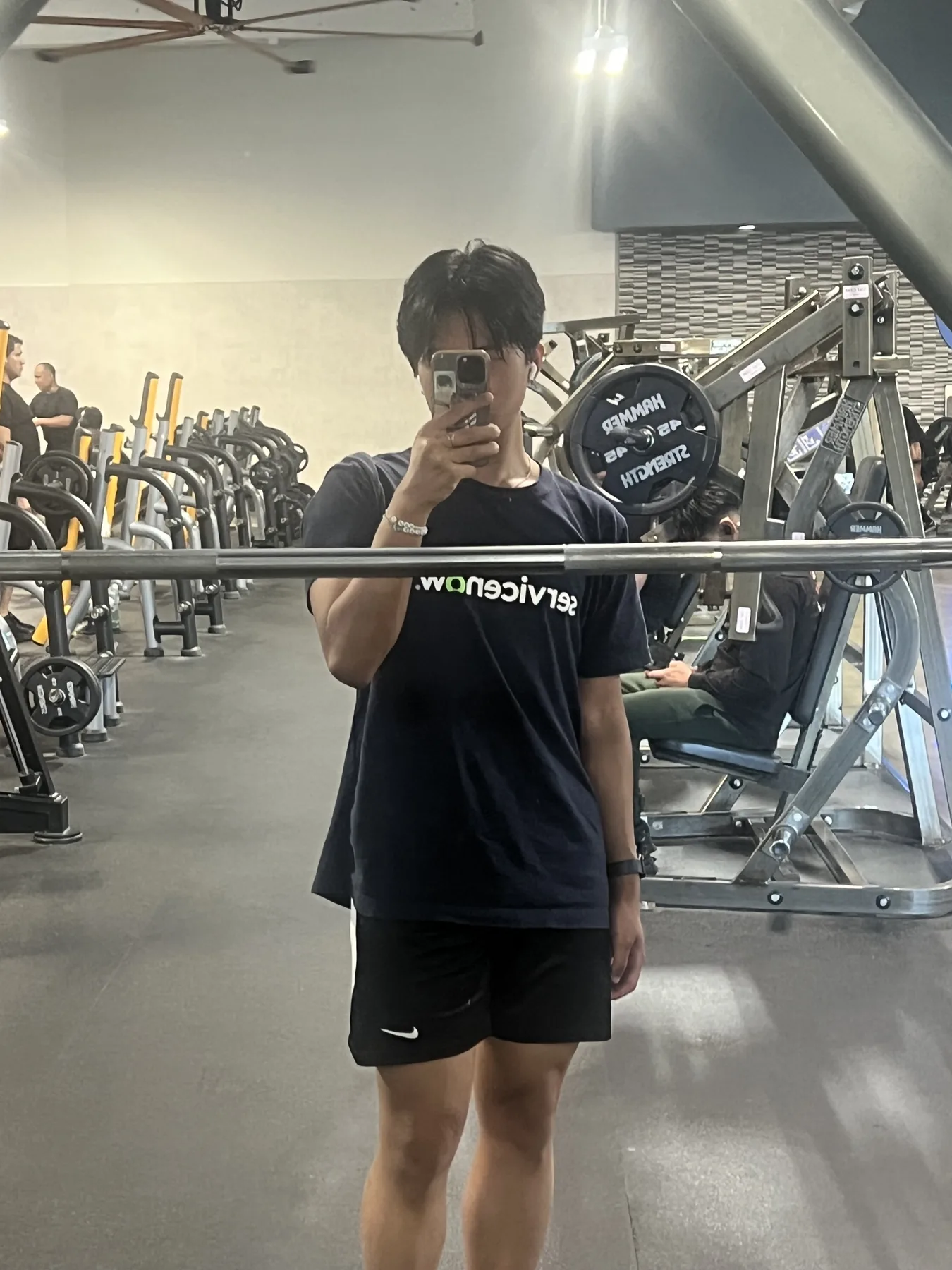 Chris taking a mirror photo at the gym while wearing a ServiceNow shirt