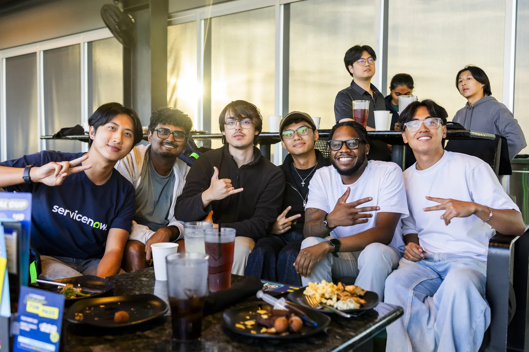 Chris seated with coworkers and friends at a dinner table during an internship gathering