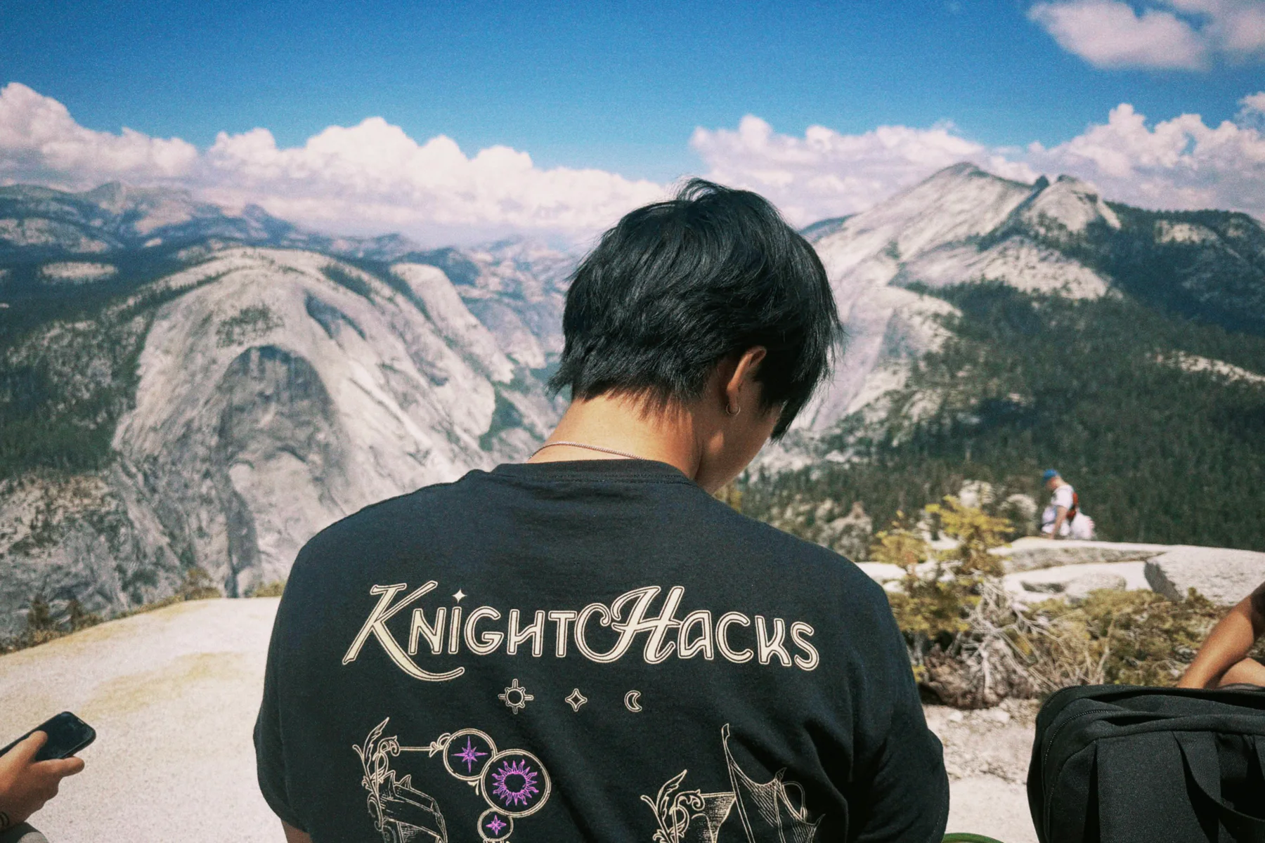 Chris wearing a Knight Hacks shirt while looking across a mountain valley